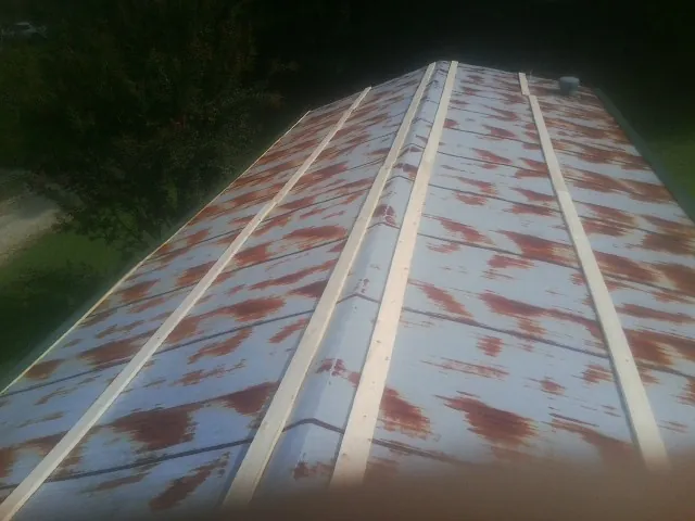 Rusted metal roof panels with new wood purlins before replacement — Storm Damage Roof Repair in Kellerton by Roofing Brothers